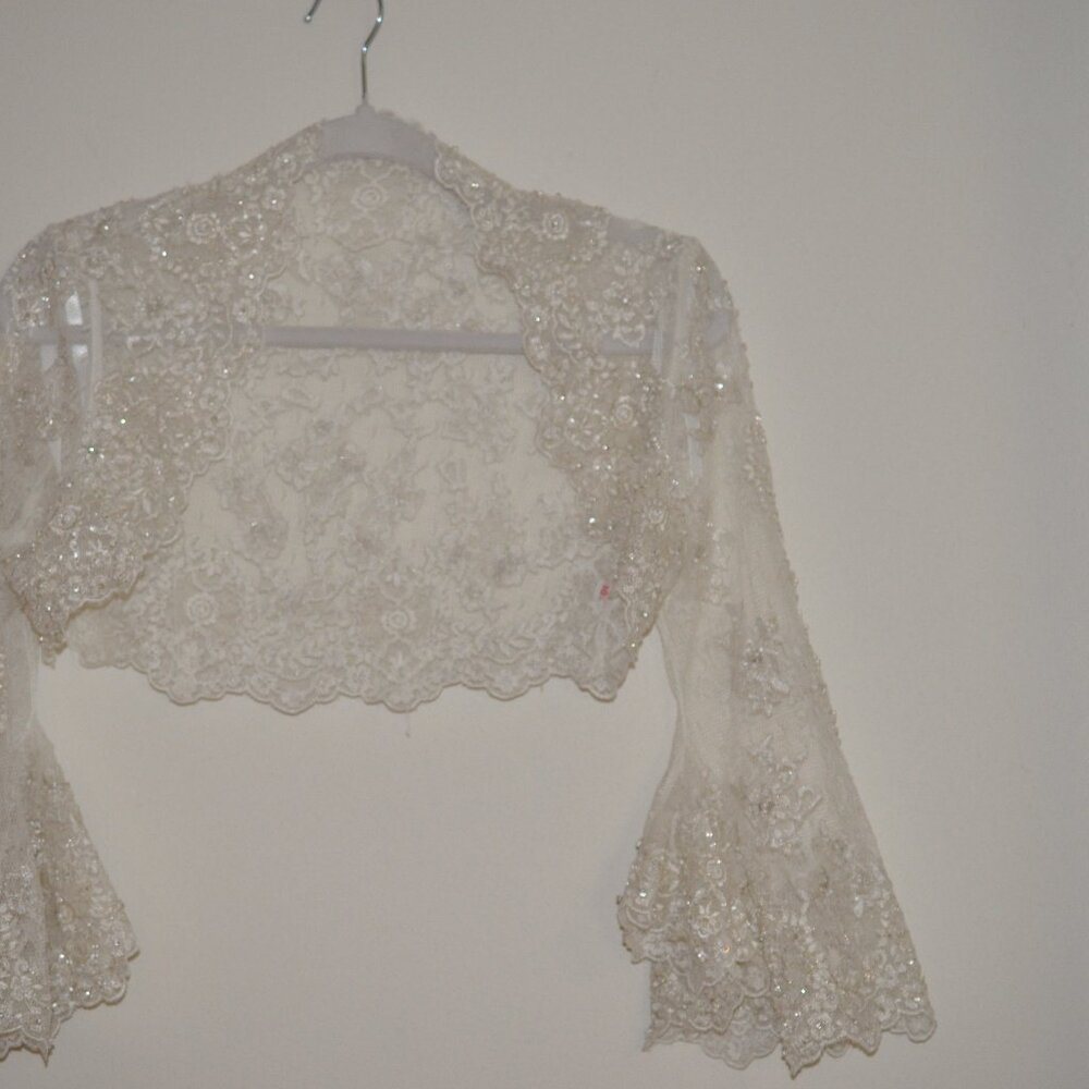 Beautiful embroidered lace bolero jacket with a a fun angled bell sleeve.